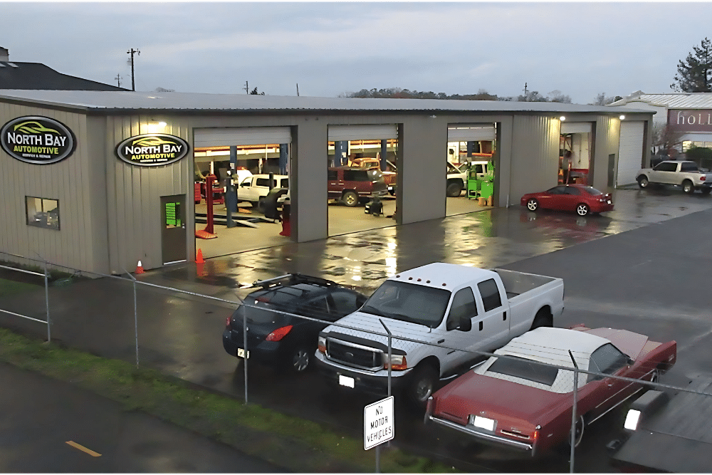certified auto repair shop, auto repair in Arcata, CA at North Bay Automotive. Image of a well-lit metal building with multiple service bays open and vehicles being serviced inside.