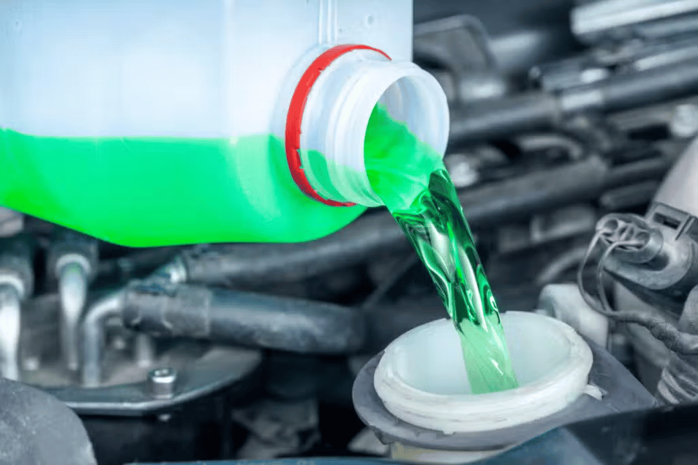 Fluid exchange service in Arcata, CA at North Bay Automotive showing coolant pouring into the reservoir during routine maintenance